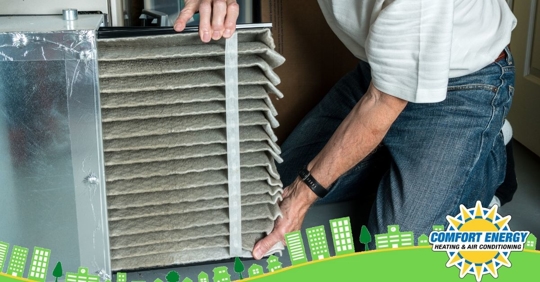 Man removing dirty air filter from HVAC system